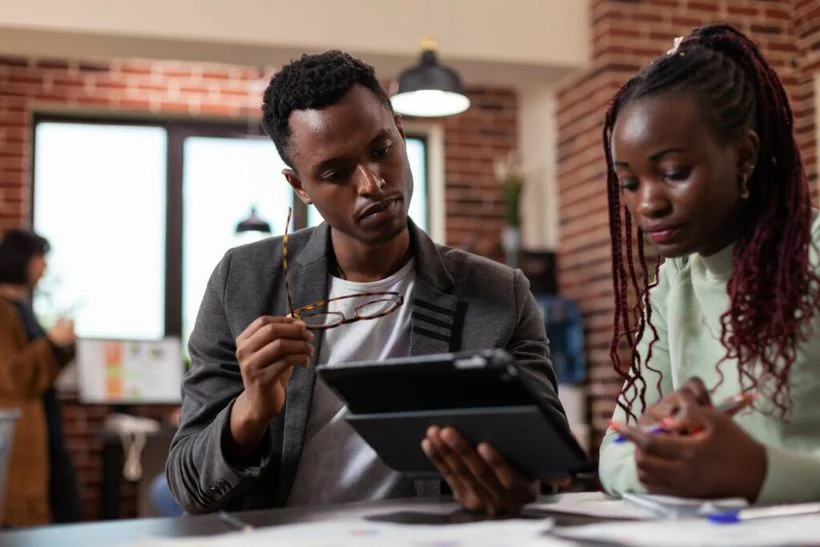 Deux collaborateurs travaillent sur une tablette