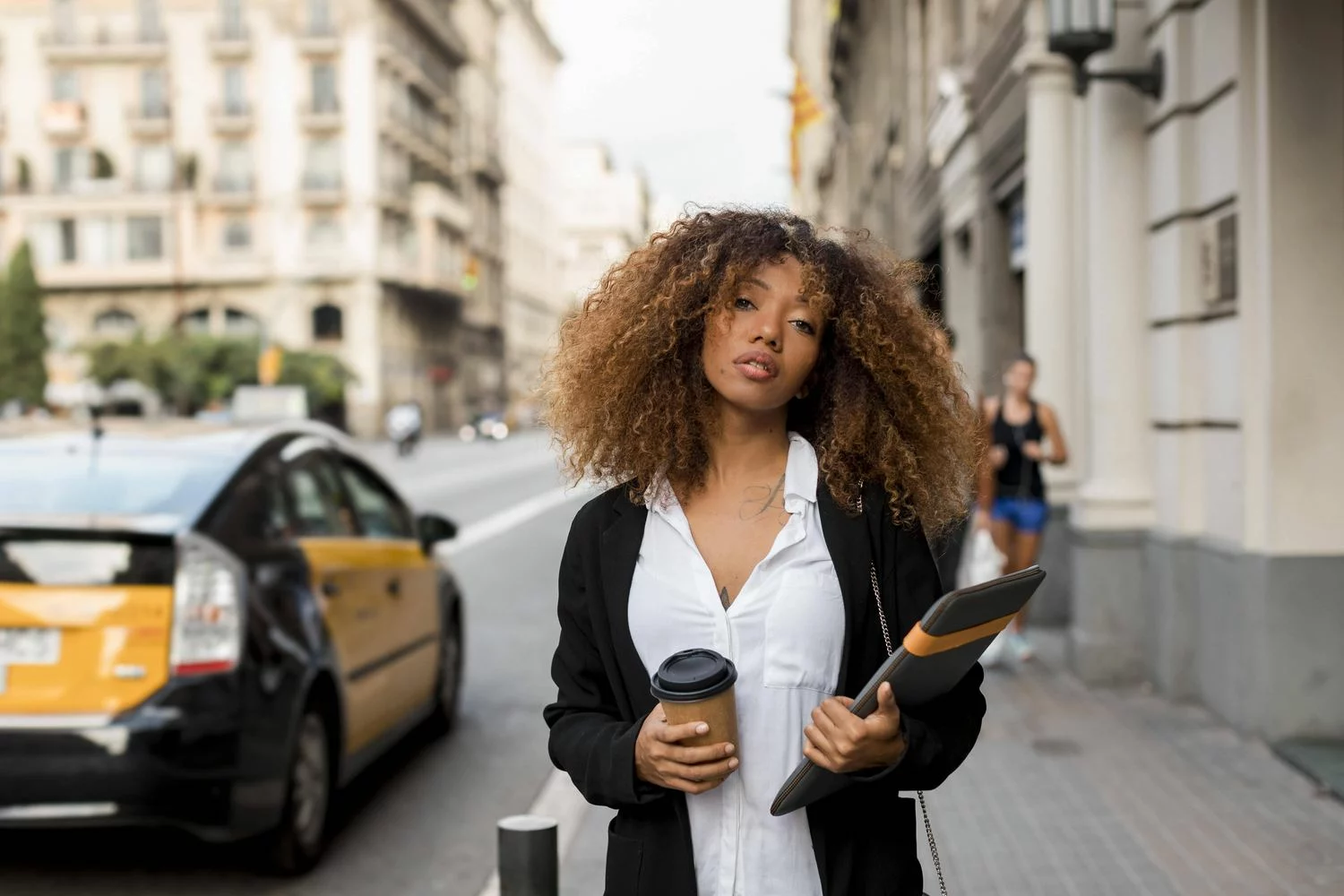 Une jeune femme marche dans une rue animée, un café à la main