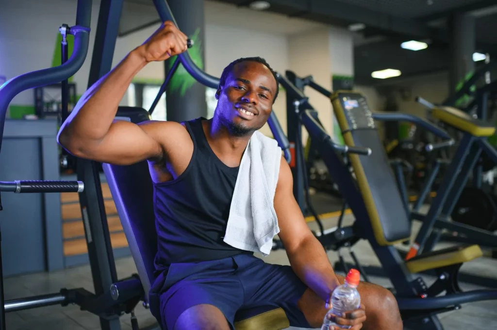 Un sportif souriant se repose dans une salle de sport